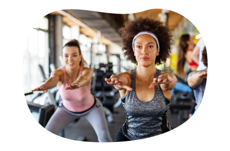 Fitness instructor guiding a class through stretches in a gym.