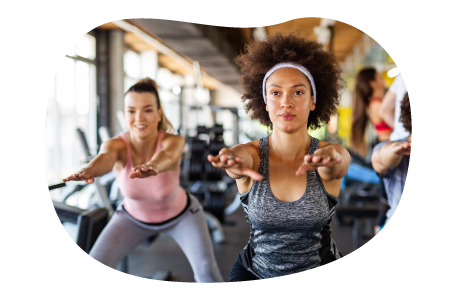 Fitness instructor guiding a class through stretches in a gym. Fitness instructor guiding a class through stretches in a gym.