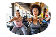 Fitness instructor guiding a class through stretches in a gym.