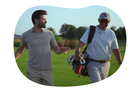 A golf instructor and their student walk across a golf course. A golf instructor and their student walk across a golf course.