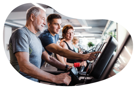 Fitness center employee helping a client on a treadmill.