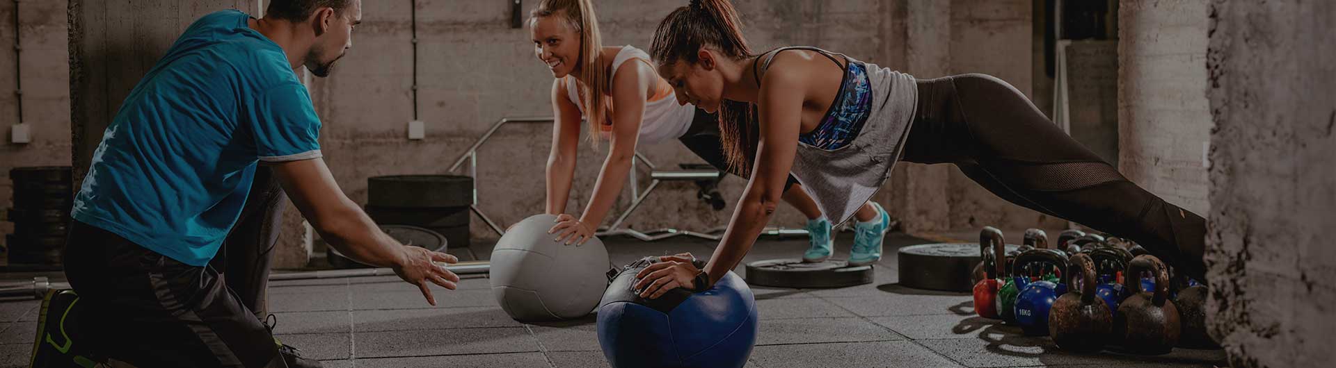 Personal trainer working with two clients on exercise balls. Personal trainer working with two clients on exercise balls.