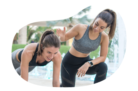 Personal trainer helping a client in a fitness center.