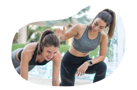 Personal trainer helping a client in a fitness center.