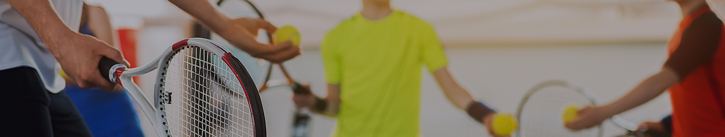 A tennis instructor coaches a group of students.