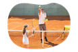 A tennis instructor tosses a ball to a student.