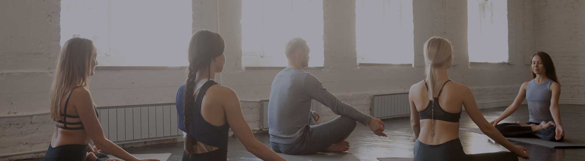 Several people sitting on the floor in a yoga class. Several people sitting on the floor in a yoga class.