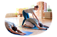 Yoga instructor guiding a person through a stretch at a studio.