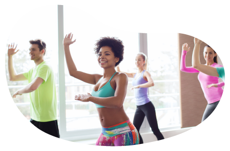 Zumba instructor guiding a class through a routine in a studio.