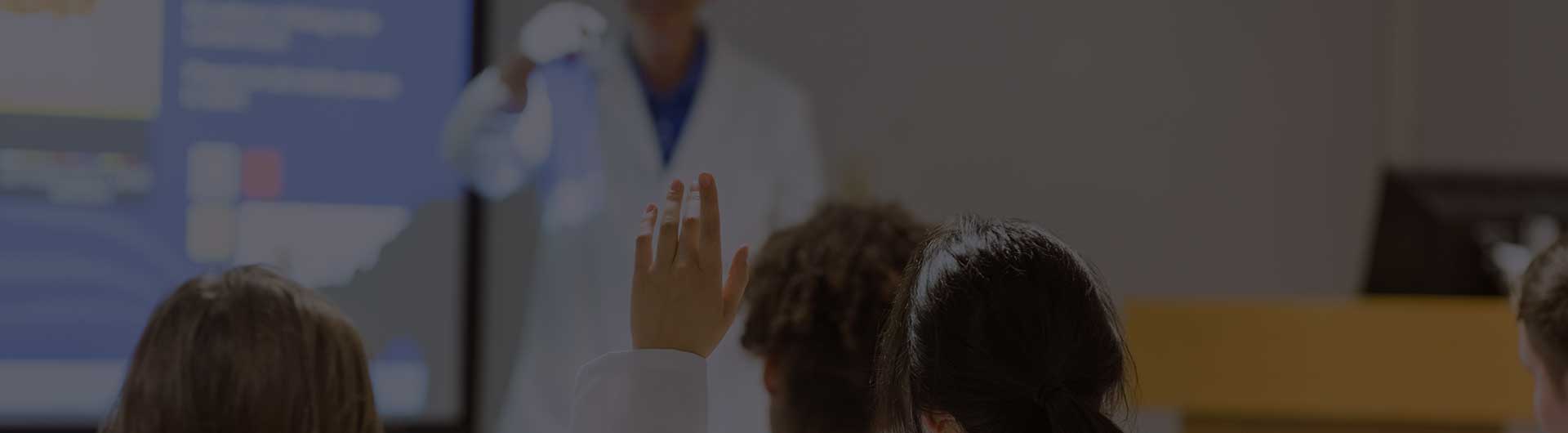 Medical professor giving lecture to a class of doctors.