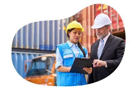 A business owner speaks with an employee at a container yard. A business owner speaks with an employee at a container yard.