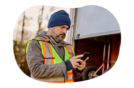 The driver of a utility trailer texting a client. The driver of a utility trailer texting a client.