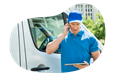 A commercial van driver talks on the phone with a client.