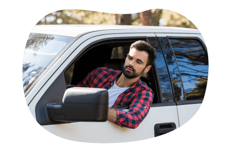 A hotshot driver looking out the window of a pickup truck. A hotshot driver looking out the window of a pickup truck.