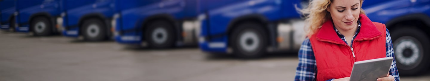 Owner operator in front of line of trucks.