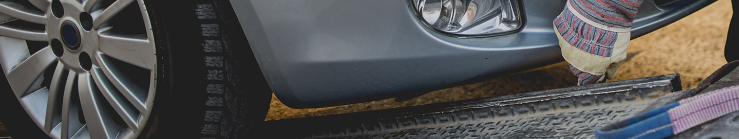 Person attaching a tow hook to a car.