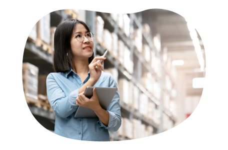 Electronics wholesaler employee checking stock of computers in a warehouse.
