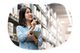 Electronics wholesaler employee checking stock of computers in a warehouse.