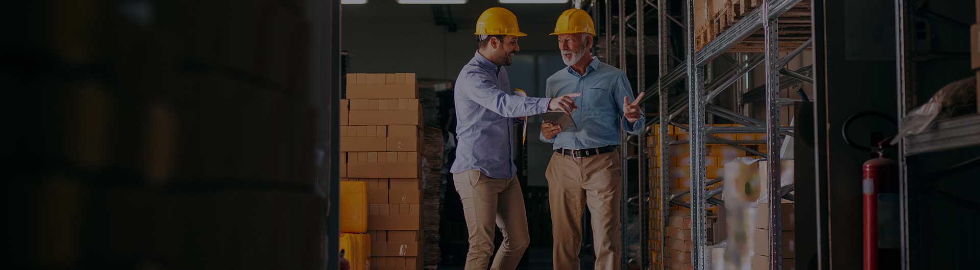 Workers walking in storage and pointing at boxes.