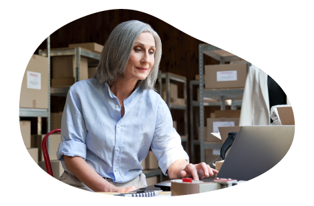 Jewelry wholesaler employee checking inventory on a laptop.