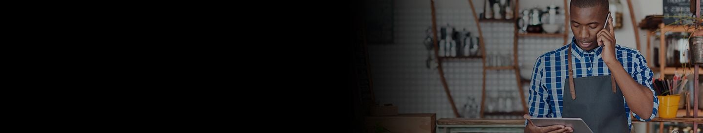 Business owner holding tablet talking on phone.