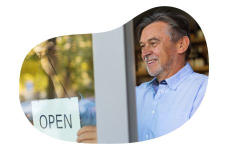 A small business owner hanging the "open" sign at their new store location