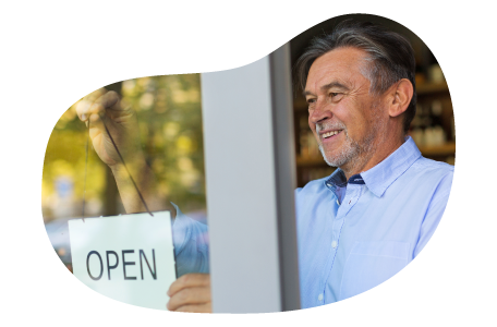 A small business owner hanging the "open" sign at their new store location A small business owner hanging the "open" sign at their new store location