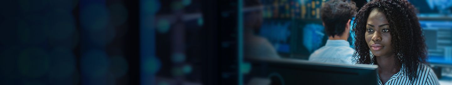 Female computer engineer working in server room.