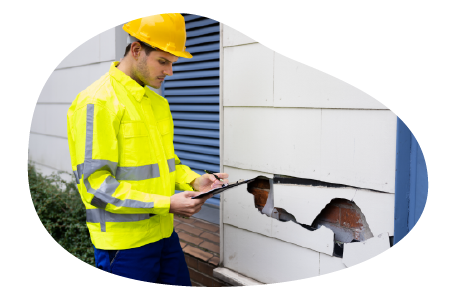 Contractor inspecting environmental damage to business property. Contractor inspecting environmental damage to business property.