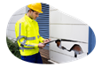 Contractor inspecting environmental damage to business property.