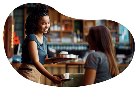 A cafe owner gives a customer their coffee order A cafe owner gives a customer their coffee order