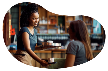 El dueño de una cafetería entrega un pedido de café a un cliente. 