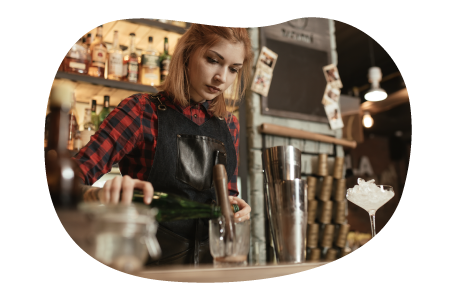 A bartender preparing a cocktail for a customer