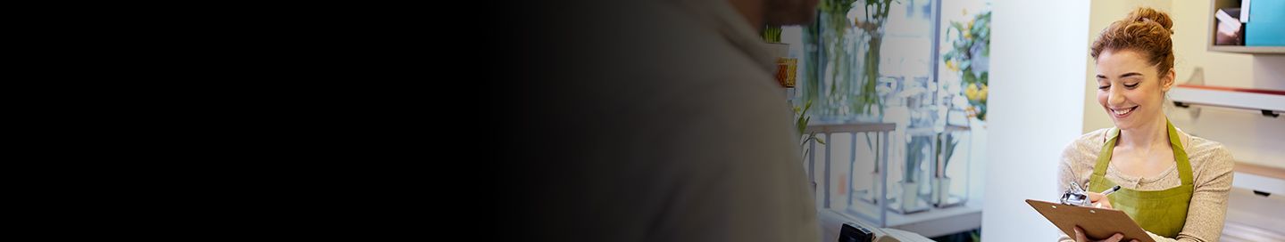 Business owner reviewing order on clipboard.